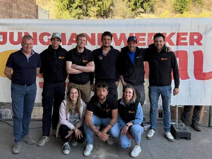 Handwerk hautnah: SkillsDay begeistert im Eggental Gruppe junger Handwerker posiert vor Banner mit Schriftzug Jungjanwerker Schweiz