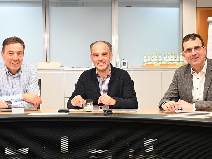 Gemeinsam für flüssigen Verkehr Drei Männer sitzen an einem Konferenztisch in einem Büro