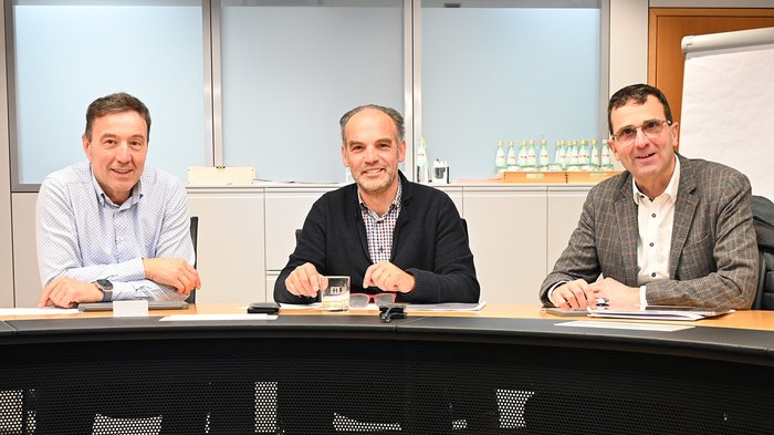 Neue übergemeindliche Gewerbezone stärkt Wirtschaftsstandort im Überetsch Drei Männer sitzen an einem Konferenztisch in einem Büro