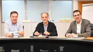 News Tre uomini seduti a un tavolo riunioni in ufficio