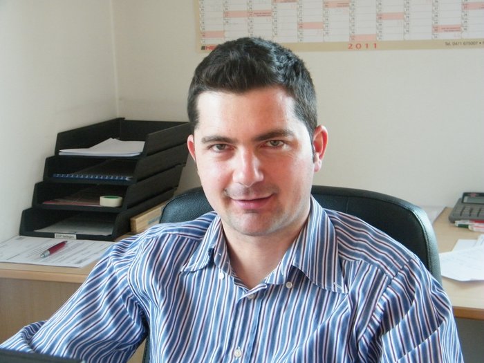 Arbeiten auf Baustellen: Sicher und mit Respekt Mann sitzt im Büro vor Schreibtisch mit Akten und Kalender an der Wand