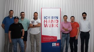 News Sieben Männer stehen neben einem Banner mit der Aufschrift Ich bin Handwerk