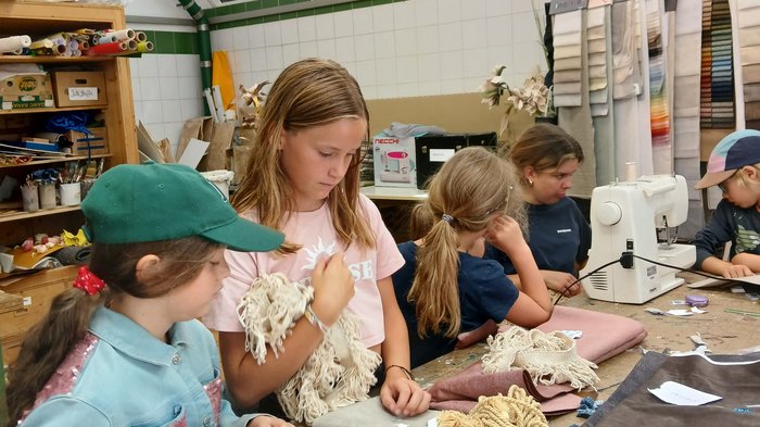 Creatività a misura di bambino: a Bressanone l’artigianato prende vita con la Kids Academy Bambini creano e cucono insieme a un tavolo in un laboratorio