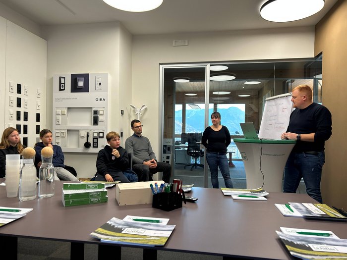 Handwerks- und Gastbetriebe im Fokus Gruppe hört Vortrag in modernem Besprechungsraum mit Blick auf Berge