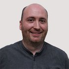 Congegnatori meccanici e attrezzisti Primo piano di un uomo calvo sorridente con barba corta