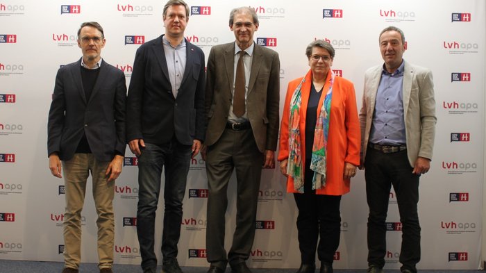 Erfolgreiche Kooperation zwischen lvh.apa und Universität Fünf Personen stehen vor einer lvhapa und Generation H Wand.