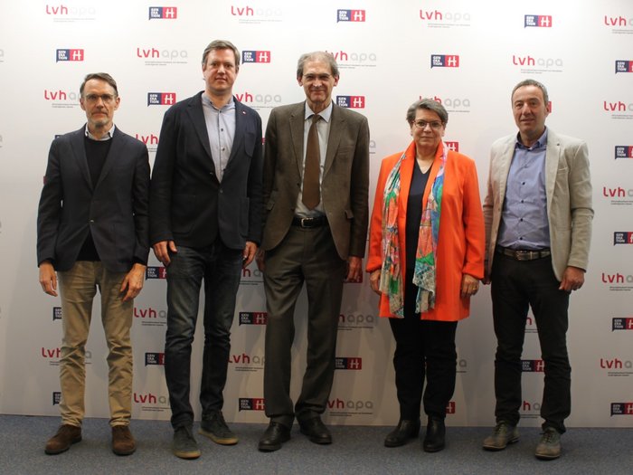 Erfolgreiche Kooperation zwischen lvh.apa und Universität Fünf Personen stehen vor einer lvhapa und Generation H Wand.