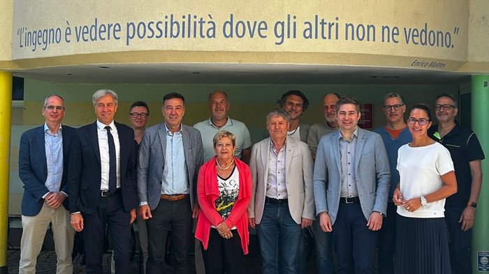 Scuola media di Brunico: lavori da sogno nei diversi settori dell'ospitalità e dell'artigianato Foto di gruppo davanti a una parete con la citazione di Enrico Mattei