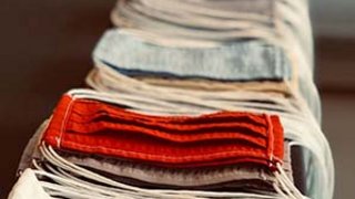 News Mehrere gefaltete Masken in verschiedenen Farben in einer Reihe auf einem Tisch