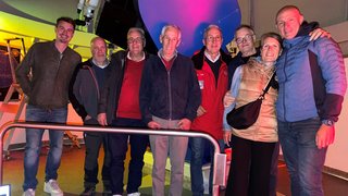 News Gruppenfoto von acht Personen in einer Sternwarte vor einem großen Teleskop