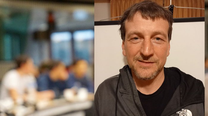 Führungswechsel an der Handwerksspitze Mann in schwarzer The North Face Jacke lächelt vor unscharfem Hintergrund