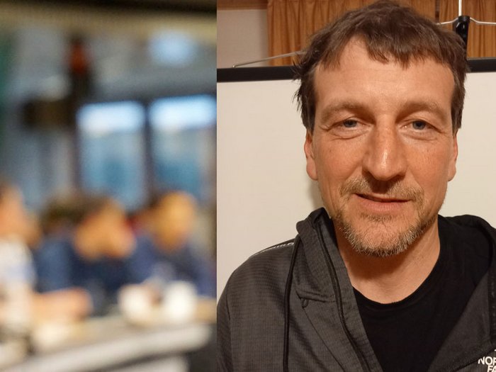 Führungswechsel an der Handwerksspitze Mann in schwarzer The North Face Jacke lächelt vor unscharfem Hintergrund