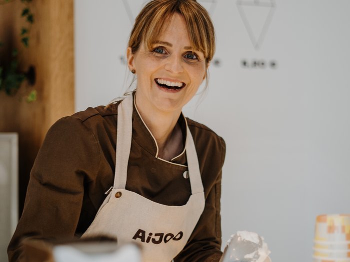 "Gambero Rosso": premiata la gelateria AiJOO Venditrice sorridente serve gelato in una gelateria