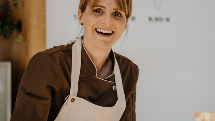 "Gambero Rosso": premiata la gelateria AiJOO Venditrice sorridente serve gelato in una gelateria