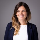 Birgit Reifer Ritratto di donna sorridente con capelli castani su sfondo grigio