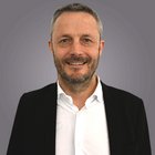 Consulenza fiscale, contabilità e calcolo della busta paga Ritratto di uomo sorridente con barba in giacca nera e camicia bianca su sfondo grigio