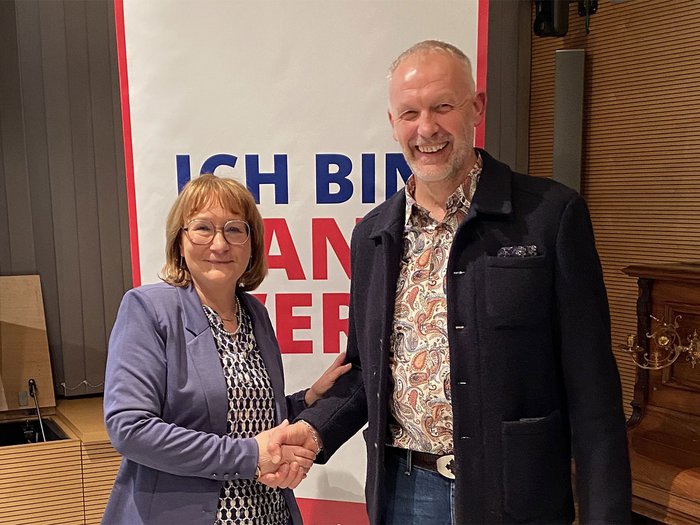 Führungswechsel im Wipptal: Thomas Kerschbaumer folgt auf Petra Holzer als lvh-Bezirksobmann Zwei Personen geben sich die Hand und lächeln vor einem Plakat