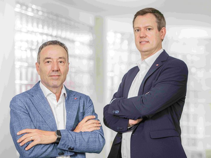 Bonus energetico Due uomini in giacca con le braccia incrociate davanti a uno sfondo chiaro