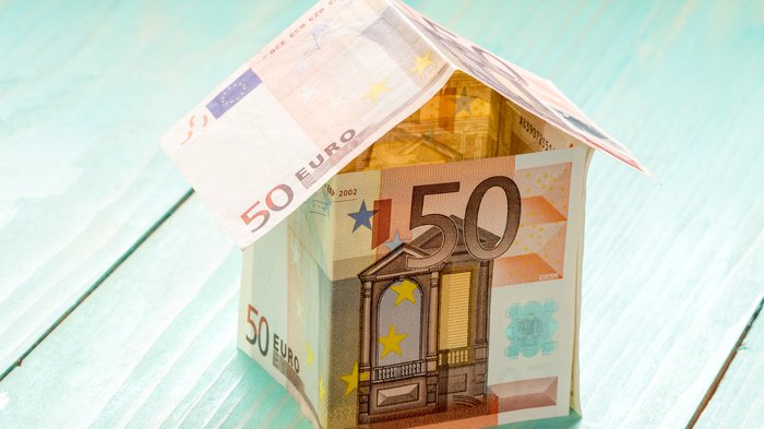 INAIL - Prämienreduzierung OT23: lvh bietet Schulungen zur Verbesserung der Arbeitssicherheit an Haus aus 50-Euro-Scheinen auf blauem Holztisch