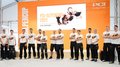 PCI-Alpencup 2022: secondo posto per i piastrellisti altoatesini! Partecipanti alla PCI Alpencup 2022 davanti a sfondo arancione e cartello pubblicitario