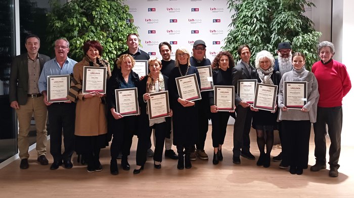 Erleichterung für die Anstellung von Lehrlingen Gruppe von 15 Personen mit Urkunden vor LVH-Hintergrund