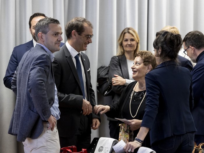 Unione provinciale dei Maestri professionali: eletto il nuovo Consiglio Persone in conversazione durante un evento formale davanti a una tenda grigia