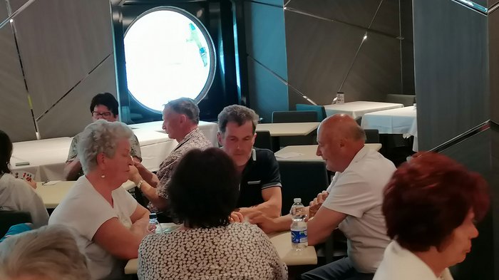 Artigiani anziani in crociera Gruppo di anziani seduti a tavoli in una stanza con finestra rotonda