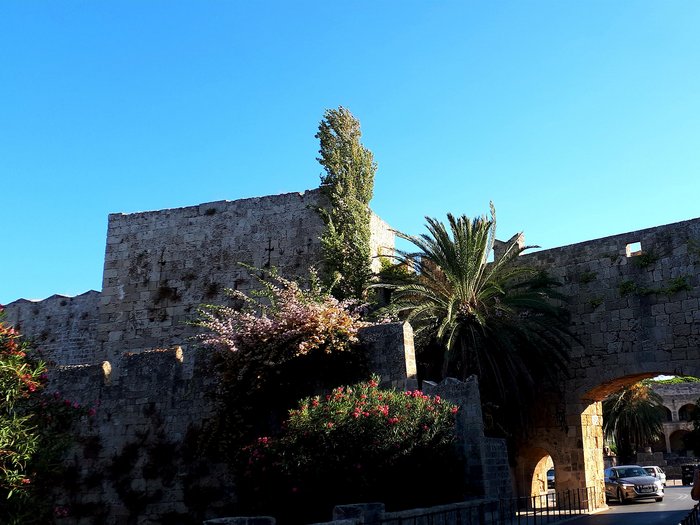 Althandwerker Rhodos 2022 © lvh.apa Historische Steinmauer mit Arkaden und Palmen unter klarem blauem Himmel