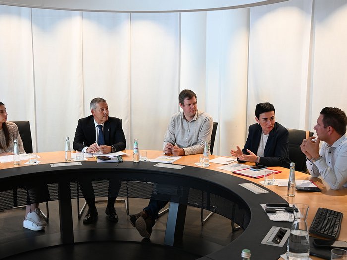 Wohnen muss leistbar sein! Herausforderungen und Lösungsansätze in Südtirol Fünf Personen diskutieren an einem runden Konferenztisch in einem Meetingraum