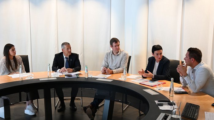 Wohnen muss leistbar sein! Herausforderungen und Lösungsansätze in Südtirol Fünf Personen diskutieren an einem runden Konferenztisch in einem Meetingraum