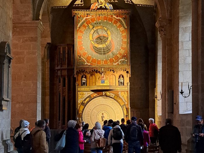 Reisefreudige Althandwerker/innen Menschen betrachten eine historische astronomische Uhr in einer Kirche