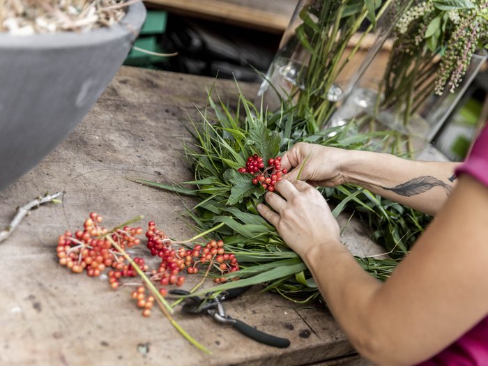 L’artigianato artistico di lvh.apa compie 75 anni Persona sistema bacche rosse e foglie verdi su un tavolo di legno