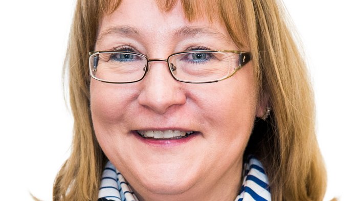 Familienfreundliche Berufswelt Porträt einer lächelnden Frau mit Brille, gestreiftem Schal und gestreiftem Pullover