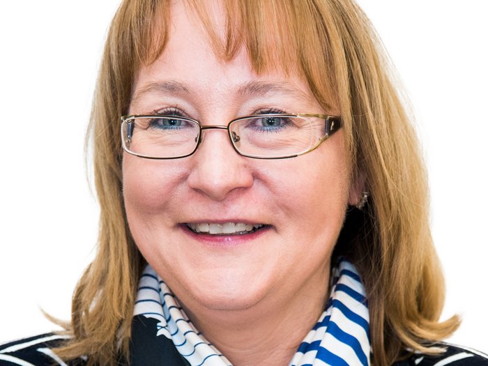 Familienfreundliche Berufswelt Porträt einer lächelnden Frau mit Brille, gestreiftem Schal und gestreiftem Pullover