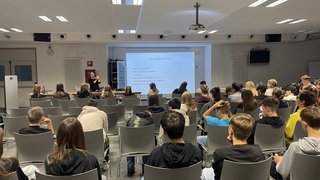 News Vortragendein im Seminarraum präsentiert vor jugendlichem Publikum