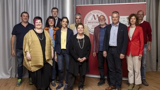 News Gruppenfoto von elf Personen vor einer roten Wand mit Meisterbund-Logo