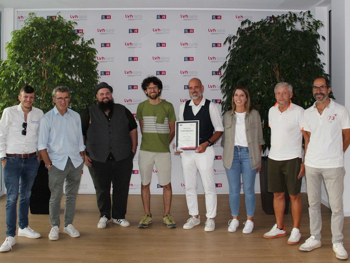 Jahresversammlung und neuer Obmann Gruppe von neun Personen, eine hält eine Urkunde, Hintergrund mit LVH APA-Logos