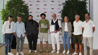 News Gruppe von neun Personen, eine hält eine Urkunde, Hintergrund mit LVH APA-Logos