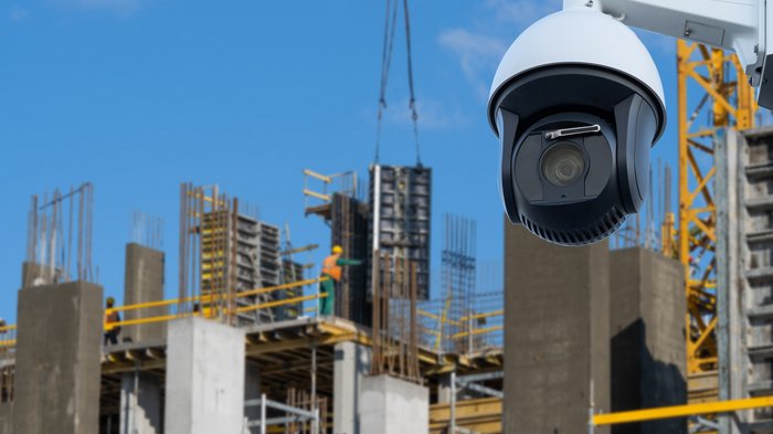 lvh warnt vor zunehmenden Diebstählen auf Baustellen Überwachungskamera beobachtet eine Baustelle mit Bauarbeitern unter klarem Himmel