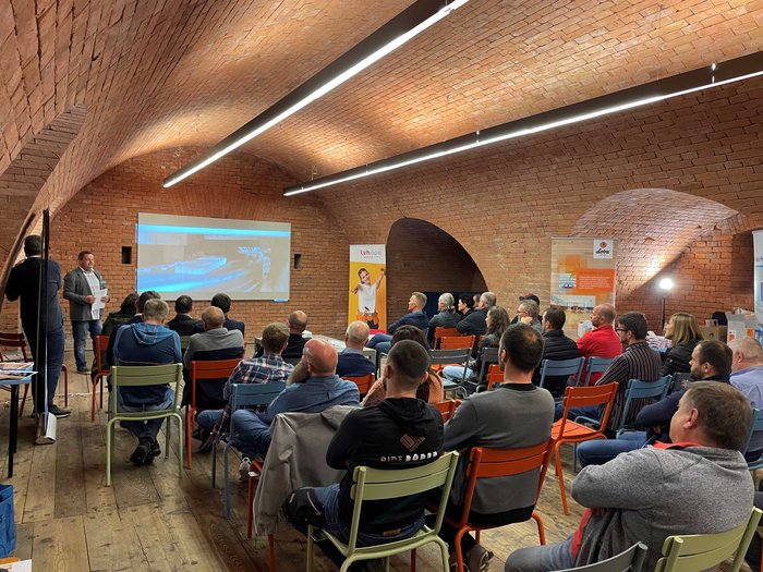 Jahresversammlung der Bodenleger/innen Publikum hört einem Vortrag in einem Raum mit gewölbter Backstein-Decke zu