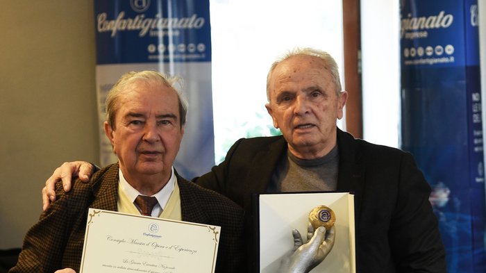 Claudio Molinari nell’Albo nazionale Due uomini anziani mostrano un certificato e un premio in un ufficio