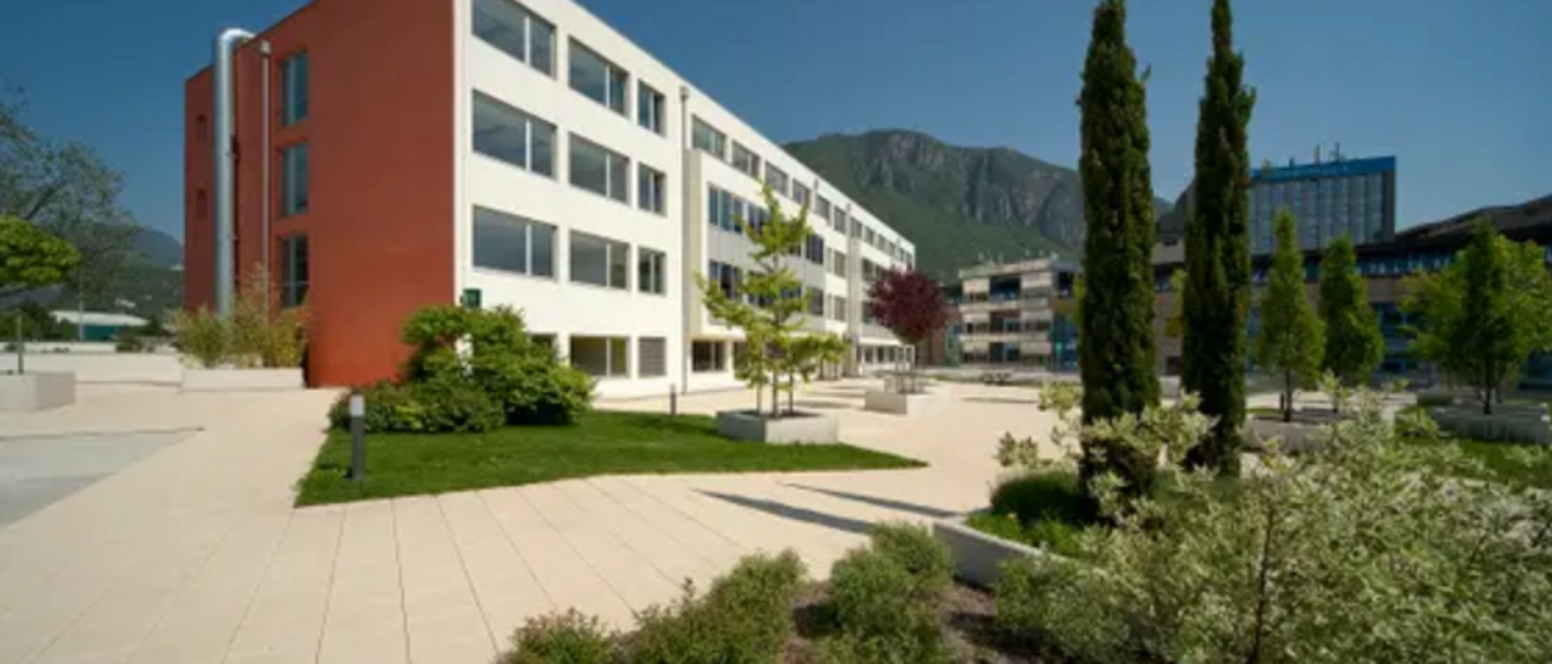 Formazione professionale Edifici moderni con terrazza e alberi davanti a montagne sotto cielo sereno