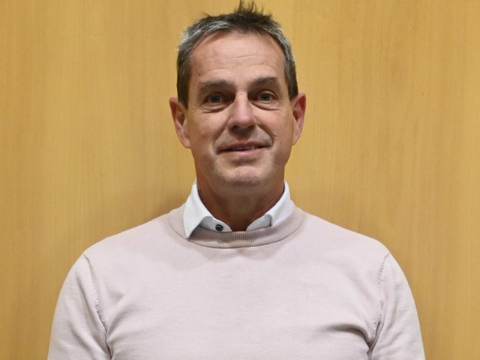 Aumento dei costi di pianificazione e di progetto: lvh.apa e i liberi professionisti chiedono misure urgenti Uomo di mezza età con capelli grigi corti e maglione rosa davanti a parete di legno