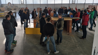 News Gruppe von Menschen in einer Werkhalle bei einer Besprechung