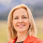 Oberpustertal Porträt einer lächelnden Frau mit blonden Haaren und rotem Blazer im Freien