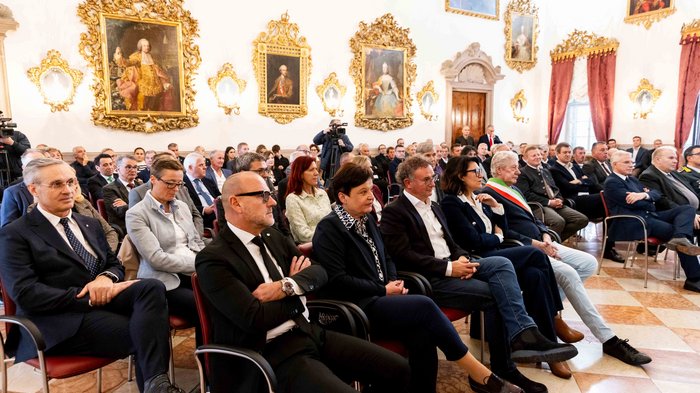 Südtiroler Wirtschaftspreis 2024 Viele Menschen hören in einem prunkvollen Raum mit Gemälden einer Veranstaltung zu