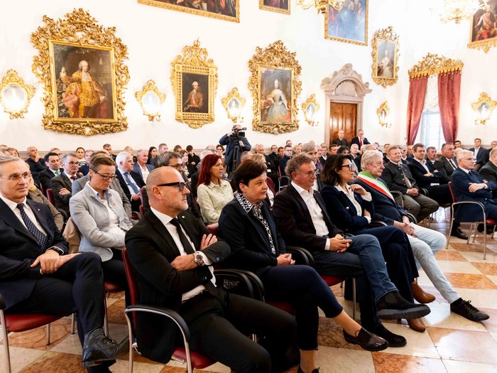 Südtiroler Wirtschaftspreis 2024 Viele Menschen hören in einem prunkvollen Raum mit Gemälden einer Veranstaltung zu