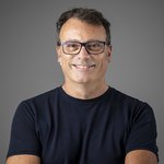 Das lvh-Team Lächelnder Mann mit Brille und blauem T-Shirt vor grauem Hintergrund