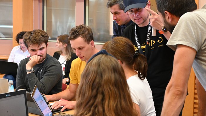 Erste lvh KI-Tage großer Erfolg Gruppe von Menschen arbeitet gemeinsam an Laptops in einem Büro