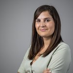 Das lvh-Team Portrait einer lächelnden Frau mit braunen Haaren vor grauem Hintergrund